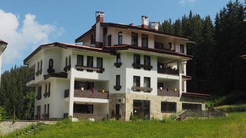 a large white building on top of a hill at High Five Villas in Pamporovo
