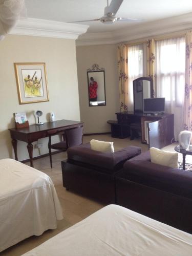 a bedroom with a couch and a table and a piano at Roc Heights in Bakau