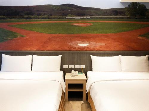 two beds in a room with a baseball field at La Hotel-Baseball Theme Hall in Kaohsiung