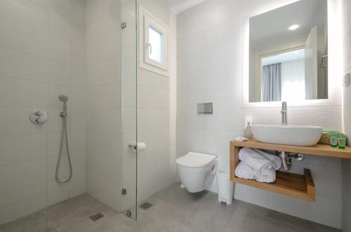 a white bathroom with a sink and a shower at 3 Wishes in Naxos Chora