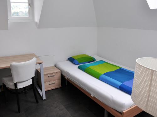 - une chambre avec un lit, un bureau et une chaise dans l'établissement August Restaurant Hotel, à Wolhusen