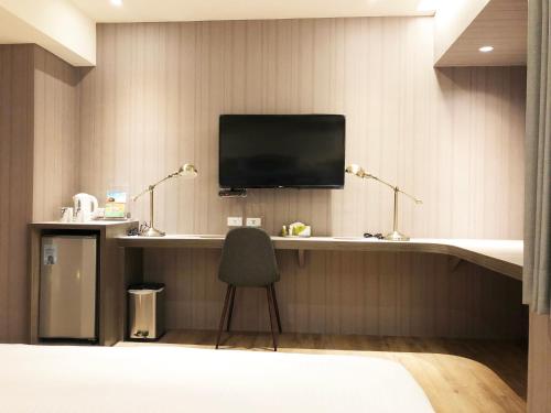 a room with a desk with a tv and a chair at La Hotel-Baseball Theme Hall in Kaohsiung