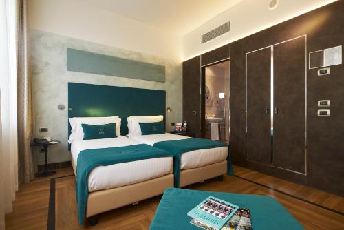 a bedroom with a large bed with a green headboard at Bianca Maria Palace Hotel in Milan