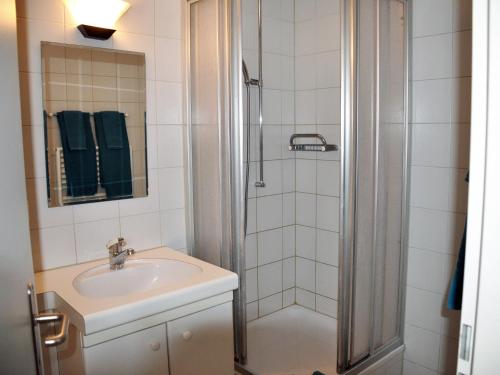 La salle de bains est pourvue d'un lavabo et d'une douche. dans l'établissement August Restaurant Hotel, à Wolhusen