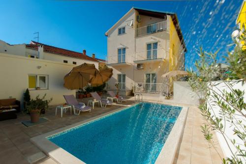 a villa with a swimming pool and a house at Apartments Batur in Zadar