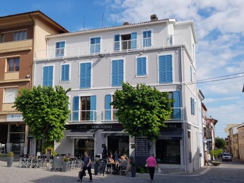 a white building with people walking in front of it at Viverenumana appartamenti la tua casa in centro a pochi passi dal mare in Numana
