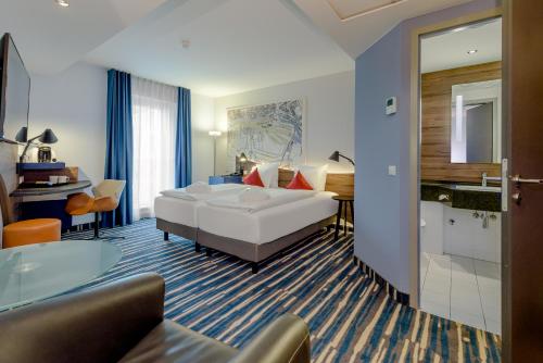 a hotel room with a bed and a bathroom at Mercure Hotel Hamburg Mitte in Hamburg