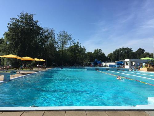 a large swimming pool with blue water at De Stadspoort appartementen in Aardenburg