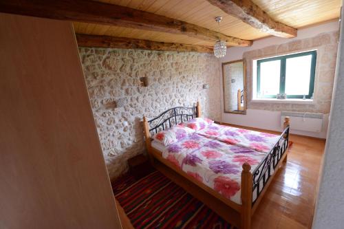 a bedroom with a bed in a stone wall at Stone Pearl in Posušje