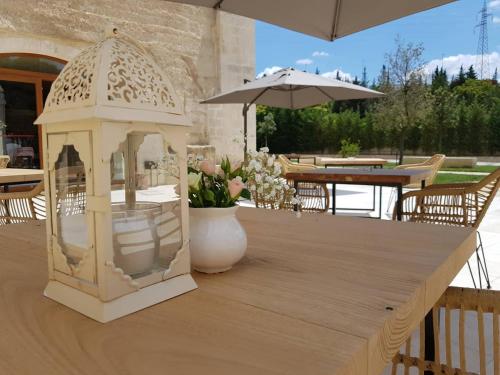 a white lantern sitting on top of a wooden table at Residence Masseria Santa Lucia in Matera