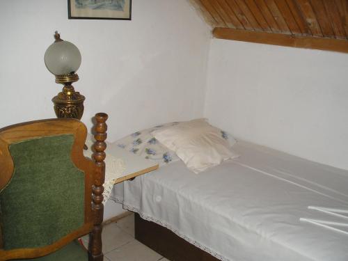 a small bedroom with a bed and a lamp at B&B Vila na Belom Bregu in Zaječar
