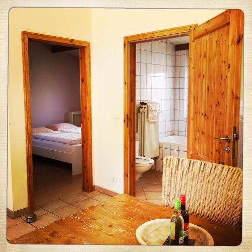 a room with a bathroom with a toilet and a table at De Munnik in Camperduin