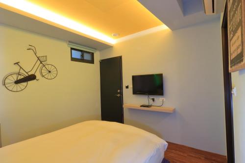 a bedroom with a bed and a bike on the wall at Amir B&B train station & elevator with parking lot in Hualien City