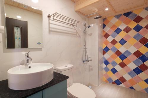 a bathroom with a sink and a toilet and a shower at Amir B&B train station & elevator with parking lot in Hualien City