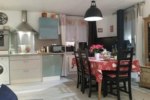 una cucina con tavolo e sedie e una cucina con tavolo e una cucina di Coeur d'Alsace 1 a Kaysersberg