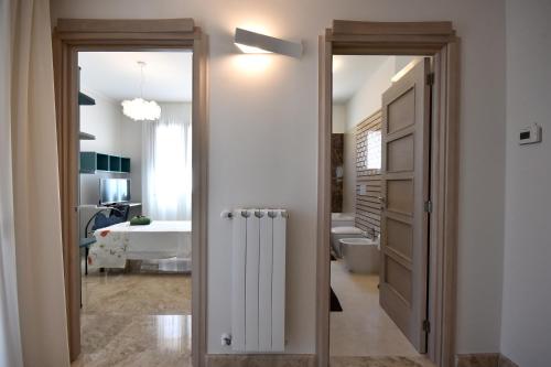 a bathroom with a door open to a bathroom with a tub at Villa Luigia Luxury Relais in Gallipoli