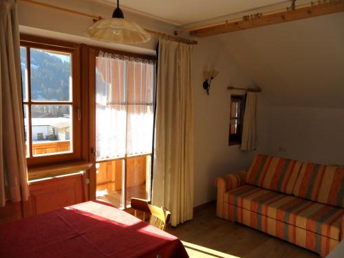 a bedroom with a bed and a window and a couch at Appartamenti Stauderhof in Villabassa