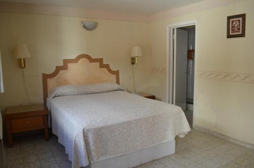 a bedroom with a bed with a white bedspread at Hotel Paraiso in Puerto Peñasco