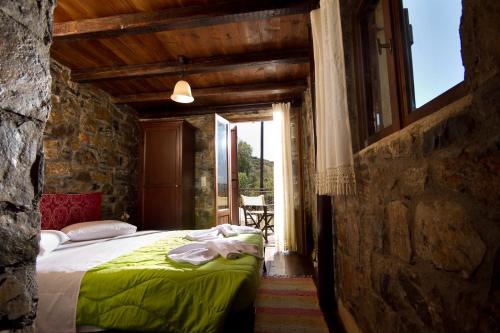 a bedroom with a bed in a stone building at Monastiraki Traditional Guest House in Monastirákion