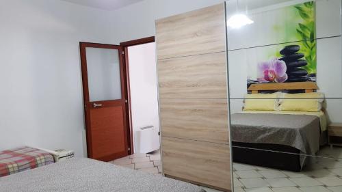 a bedroom with two beds and a mirrored wall at villa del maestro in Lenola