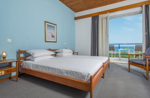 a bedroom with a bed and a view of the ocean at Delfinia Hotel & Bungalows in Mithymna