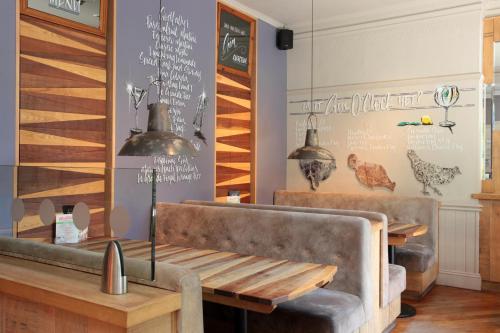 uma sala de jantar com um sofá e uma mesa em Bear Inn, Somerset by Marston's Inns em Street