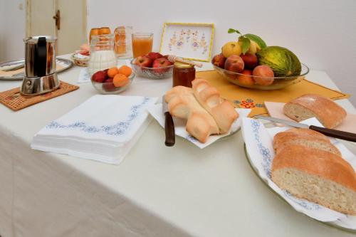 a table with bread and a bowl of fruit at B&B Sa domo de sos Massaios in Orosei
