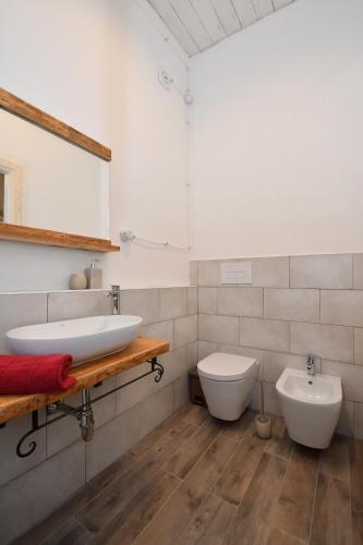 a bathroom with two sinks and a toilet at B&B Sa domo de sos Massaios in Orosei