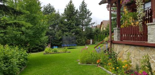 a garden with flowers and plants on a house at Noclegi Barbara in Czorsztyn