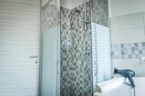 a shower with a glass door next to a toilet at Appartamenti La Sirena in Serina