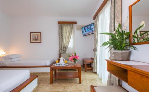 a hotel room with a bed and a table with flowers at Delfinia Hotel & Bungalows in Mithymna