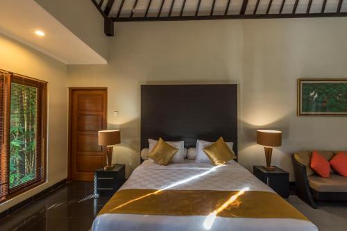 a bedroom with a large bed and a couch at Askara Villa in Canggu