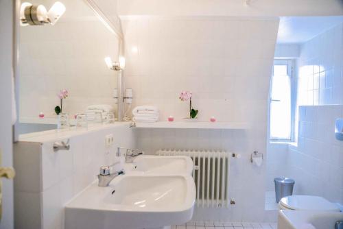 a white bathroom with a sink and a mirror at Hotel Engel in Hilders