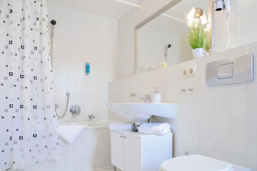 a white bathroom with a sink and a toilet at Hotel Engel in Hilders