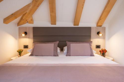 a bedroom with a large white bed with pink pillows at Boutique B&B Villa Faggioni in Cavtat
