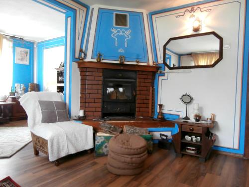 a living room with a fireplace and a chair and a mirror at The Gates Apartments in Koprivshtitsa