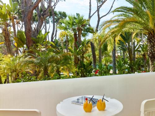 two rubber ducks sitting on a table in front of trees at Ria Park Garden Hotel in Vale do Lobo
