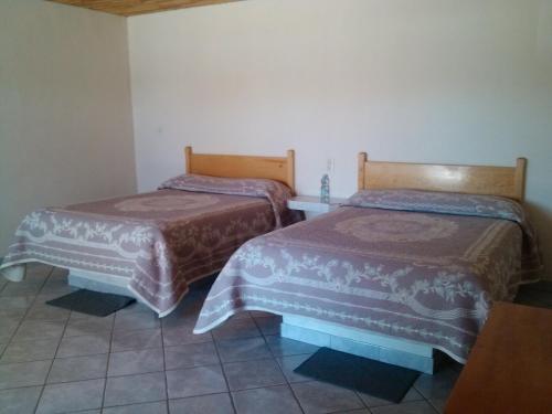 two beds in a small room at Cabaña Los Portales in Areponapuchi