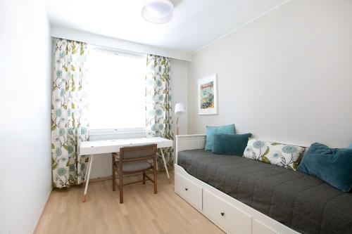 Schlafzimmer mit einem Bett, einem Schreibtisch und einem Fenster in der Unterkunft Design Apartments Kristiina in Naantali