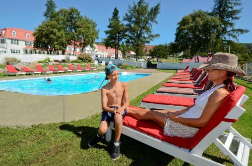a man sitting on a bench in front of a pool at Hotel Tadoussac in Tadoussac