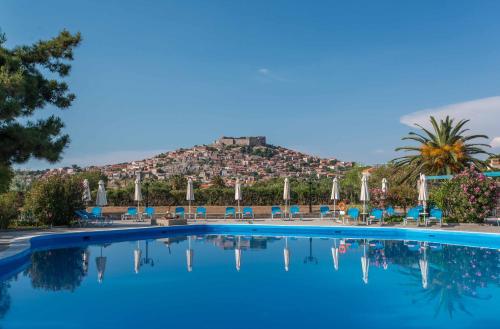 a swimming pool with a mountain in the background at Delfinia Hotel & Bungalows in Mithymna