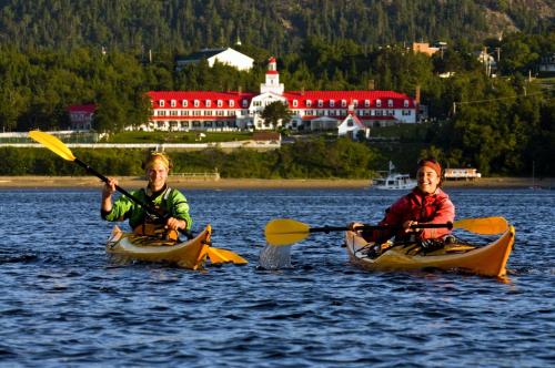 two young children are in kayaks in the water at Hotel Tadoussac in Tadoussac