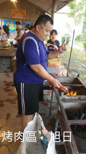 a man cooking a hot dog on a grill at Yuli Sun Homestay in Yuli