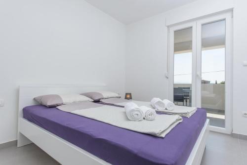 a white room with a bed with towels on it at TiaMar in Slatine