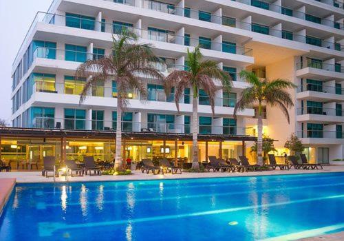 a hotel with a swimming pool in front of a building at Apartamento seaway 935 Morros, La Boquilla in Cartagena de Indias
