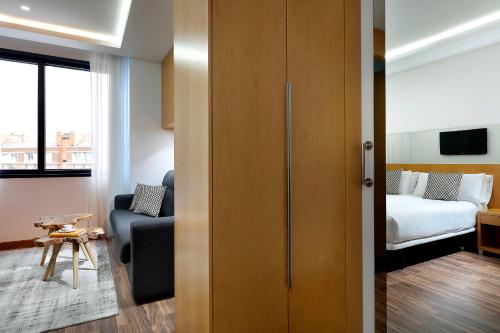 a room with a bed and a couch and a bedroom at Hotel SB Icaria in Barcelona