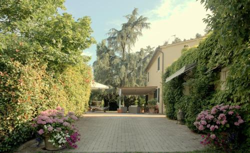 a brick walkway with flowers and a building at LAGO GABBIANO PODERe CASANOVA in Pistoia