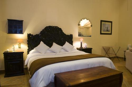 a bedroom with a large bed with a wooden headboard at Casalinda San Miguel in San Miguel de Allende