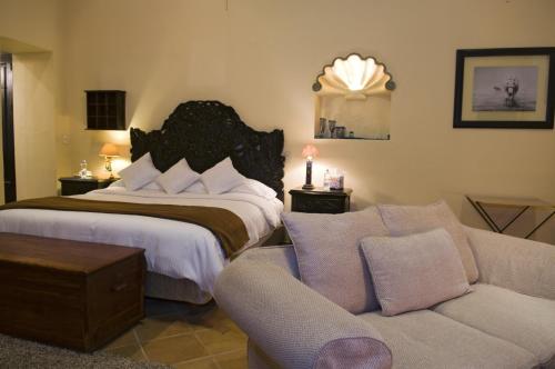 a bedroom with a bed and a couch at Casalinda San Miguel in San Miguel de Allende