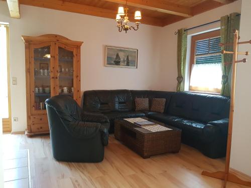 a living room with a black leather couch and chairs at Ferienanlage Beatrix in Stegersbach